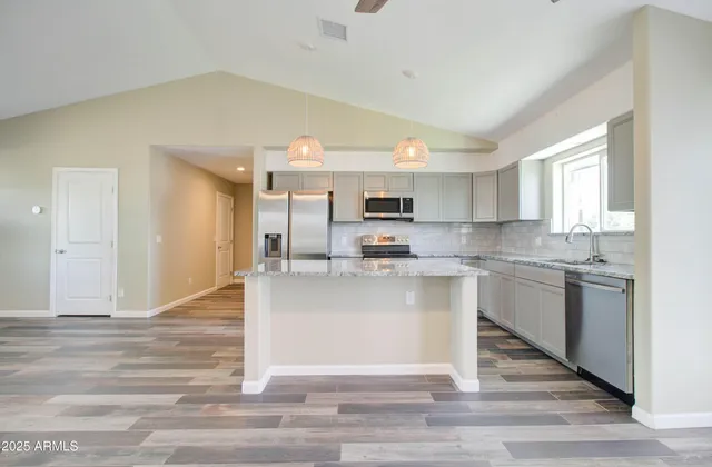 a kitchen with stainless steel appliances granite countertop a sink refrigerator and microwave