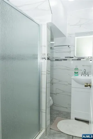 a bathroom with a shower a toilet and sink