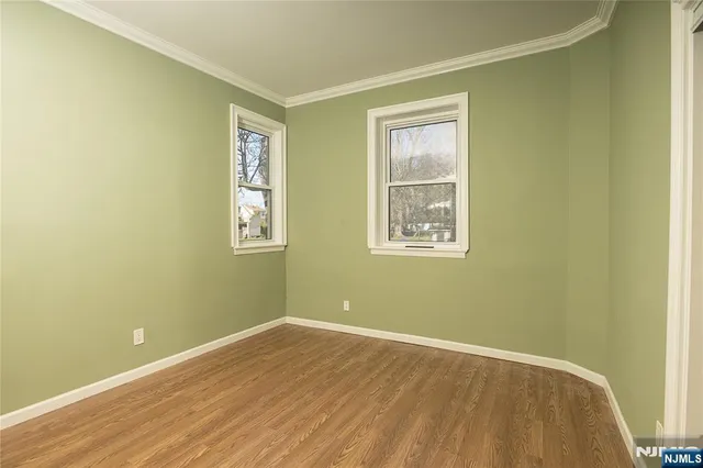 a view of a big room with wooden floor and windows