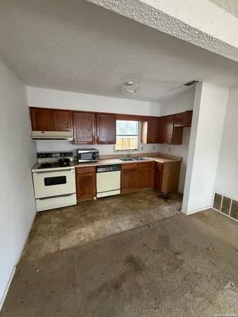 a kitchen with stainless steel appliances granite countertop a stove top oven and sink
