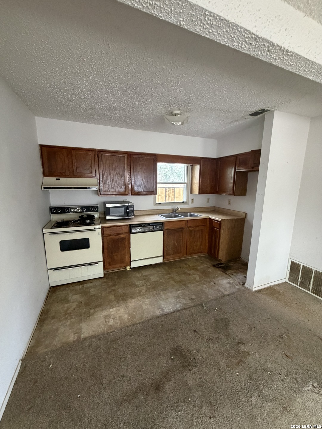 a kitchen with stainless steel appliances granite countertop a stove top oven and sink
