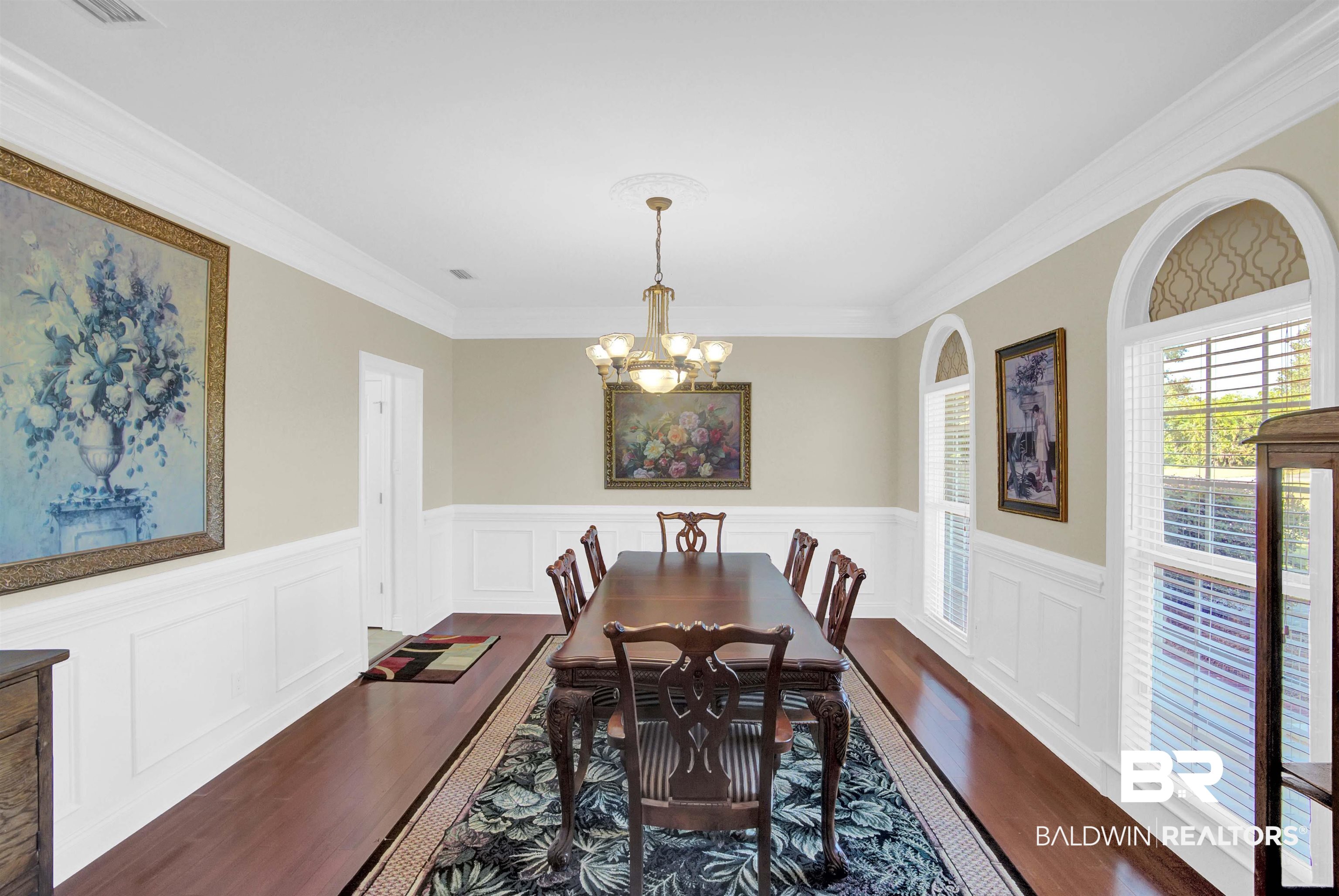 27688 Rigsby Road Daphne, AL 36526 - Photo 10 of 56 Dining room featuring hardwood / wood-style floors, crown molding, and a notable chandelier