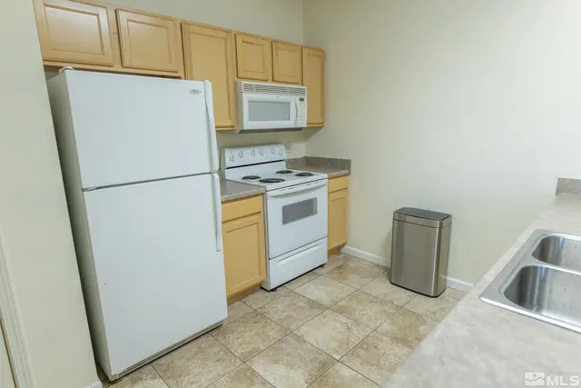 a white refrigerator freezer and a stove sitting inside of a kitchen
