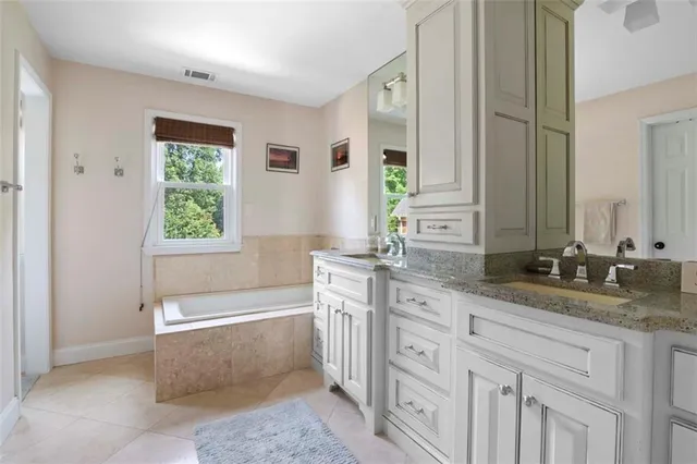 a spacious bathroom with sinks mirror and a bathtub