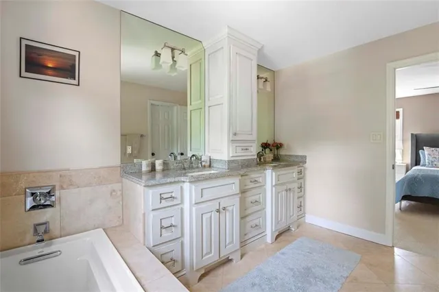 a spacious bathroom with a double vanity sink a mirror and a
