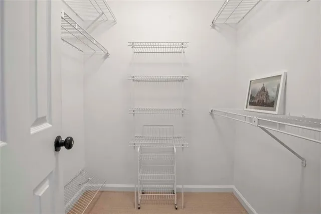 a view of walk in closet with empty racks