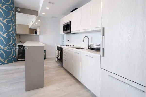 a kitchen with stainless steel appliances granite countertop a refrigerator sink stove microwave and cabinets