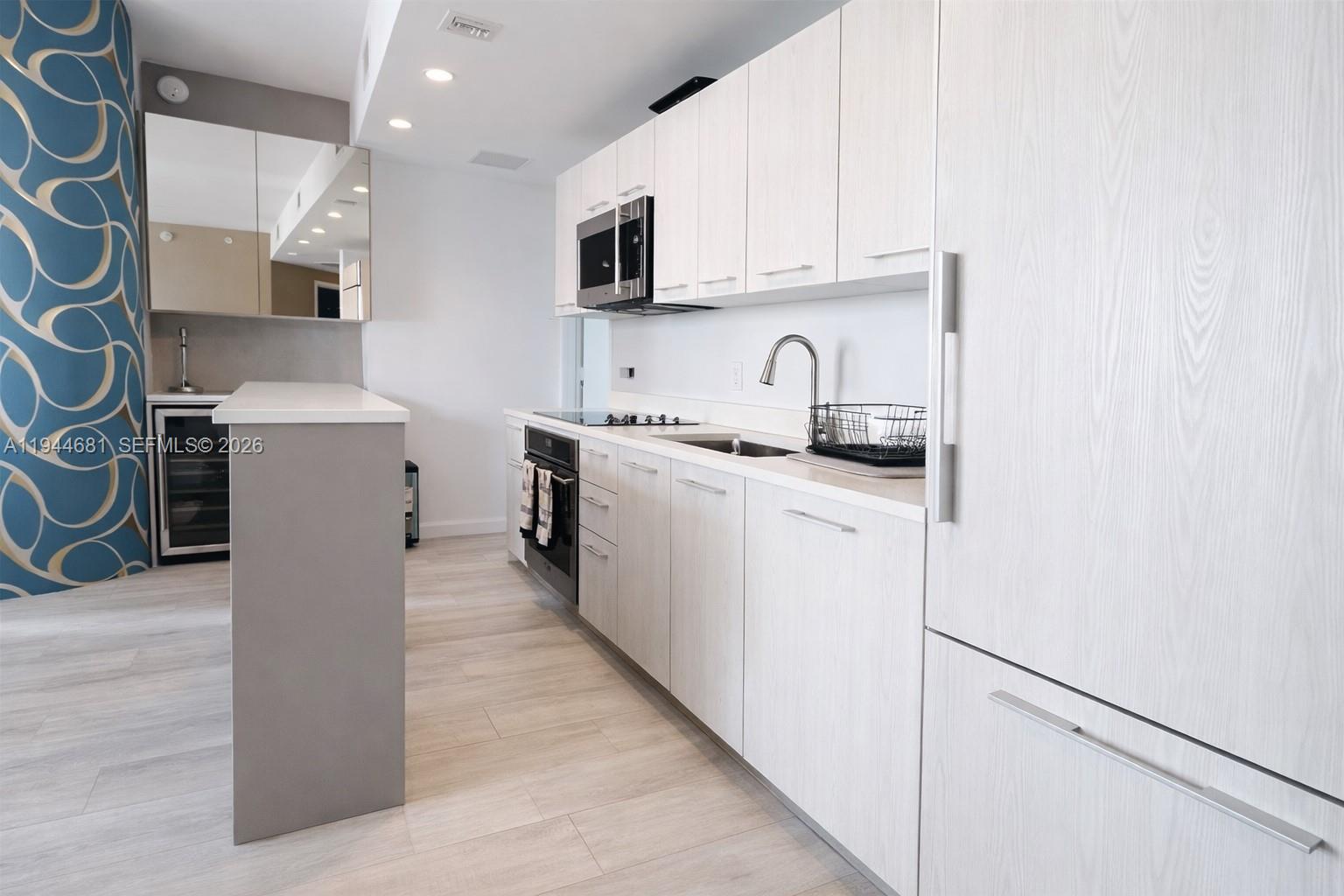 45 Southwest 9th Street, Unit 3008 Miami, FL 33130 - Photo 3 of 16 a kitchen with stainless steel appliances granite countertop a refrigerator sink stove microwave and cabinets