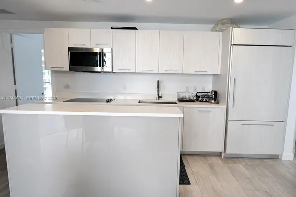 a kitchen with stainless steel appliances a refrigerator sink and microwave