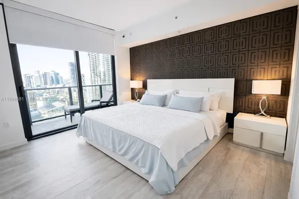 a bedroom with a bed and a large window