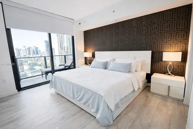 a bedroom with a bed and a large window