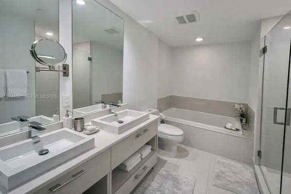 a bathroom with a sink double vanity granite tub and shower
