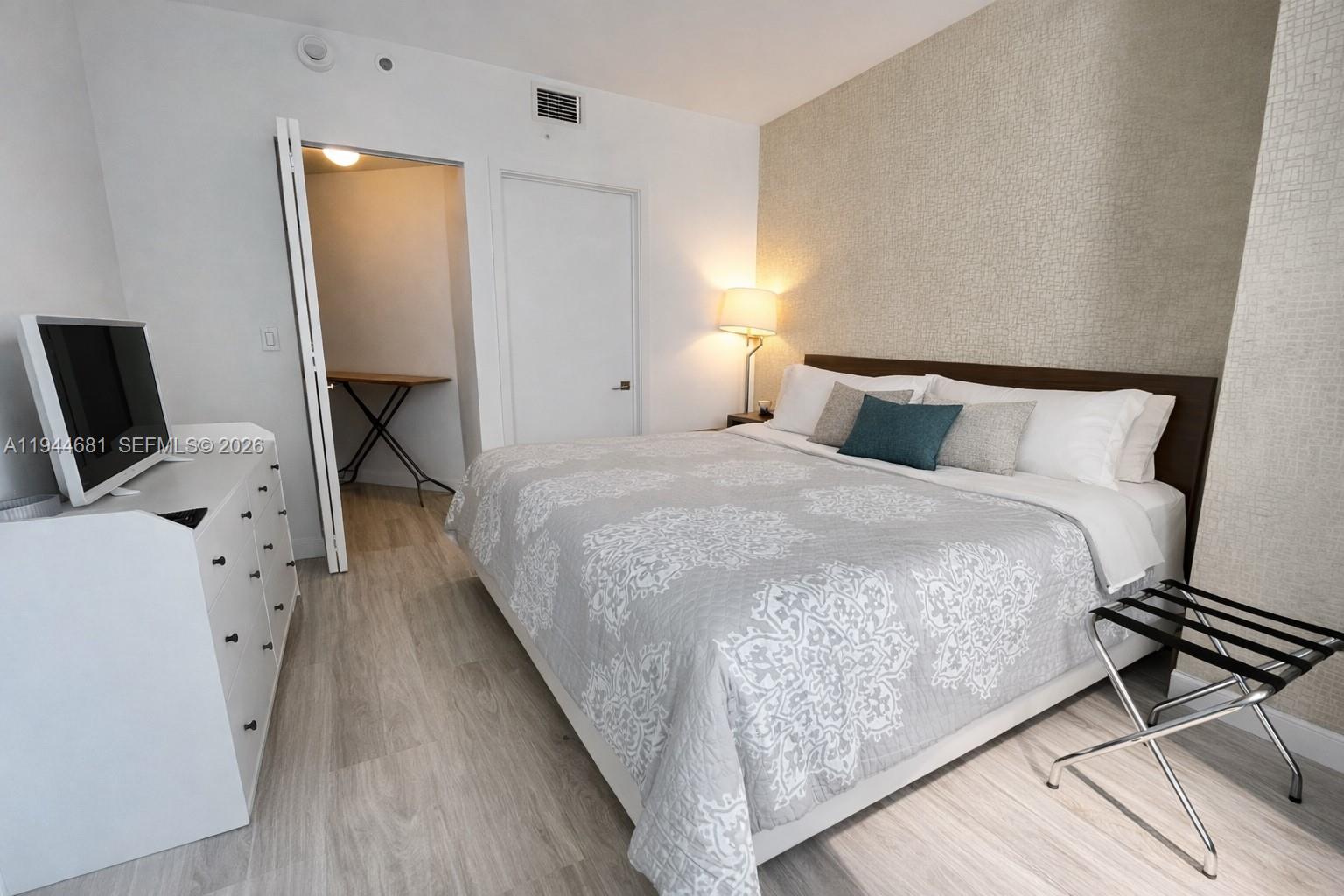 45 Southwest 9th Street, Unit 3008 Miami, FL 33130 - Photo 9 of 16 a bedroom with a bed and a flat tv screen on the dresser