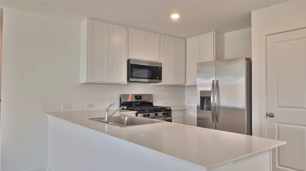 a kitchen with kitchen island a counter top space a stove and cabinets
