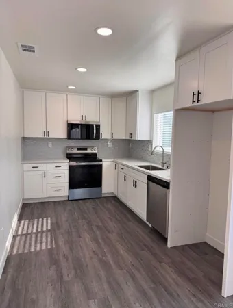 a kitchen with granite countertop a sink and steel appliances