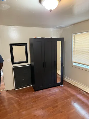 a view of an empty room with closet and a window