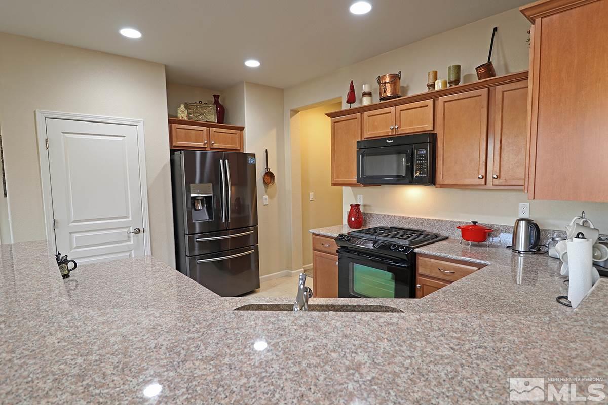 1142 Callaway Trail Reno, NV 89523 - Photo 7 of 21 a kitchen with stainless steel appliances granite countertop a refrigerator and a stove top oven