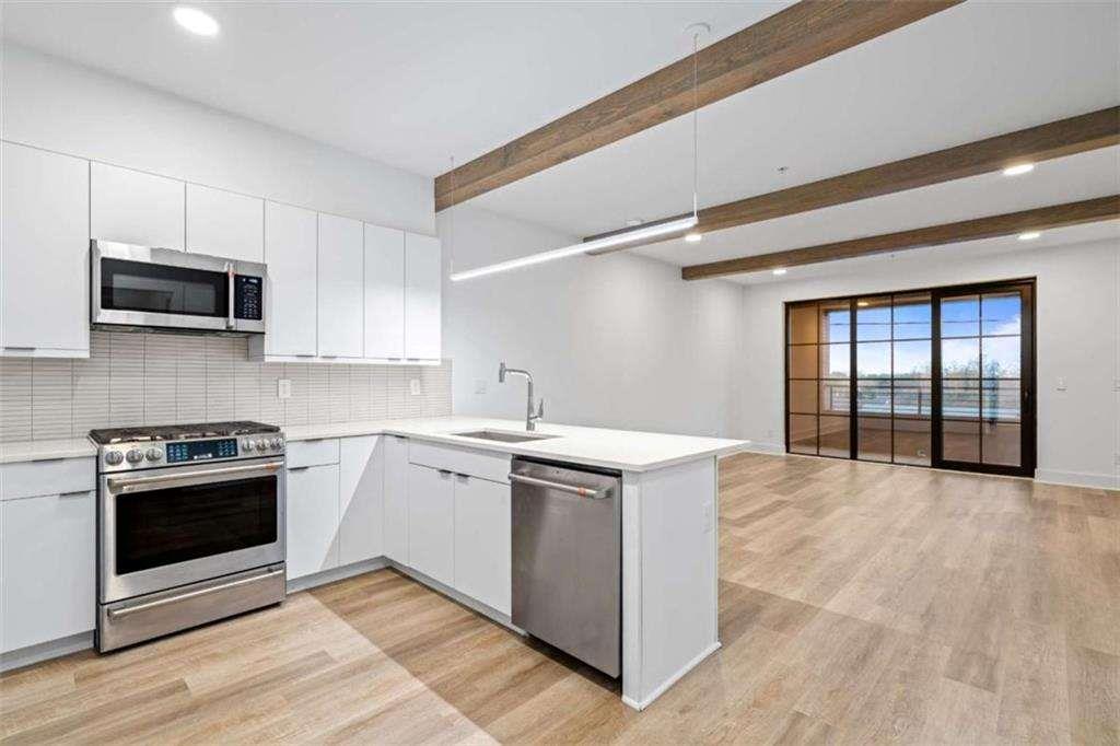 a kitchen with stainless steel appliances granite countertop a stove and a microwave