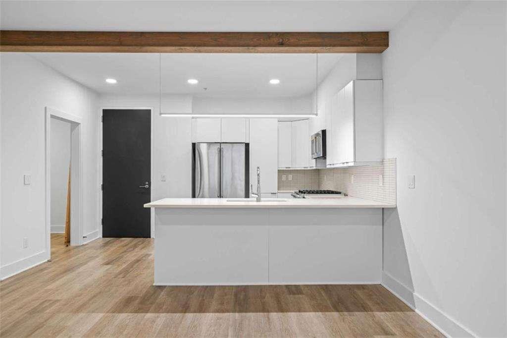 346 Peters Street Southwest, Unit 308 Atlanta, GA 30313 - Photo 8 of 19 a large kitchen with granite countertop a stove a sink and a refrigerator