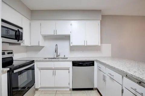 8230 El Retiro Road Fort Worth, TX 76116 - Photo 19 of 21 a kitchen with white cabinets and white appliances
