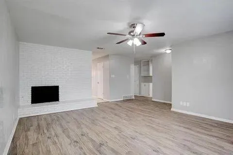 a view of an empty room with a fireplace and a window