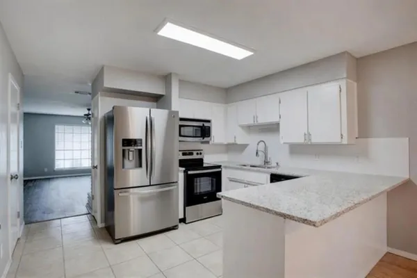 a kitchen with a refrigerator a microwave and cabinets