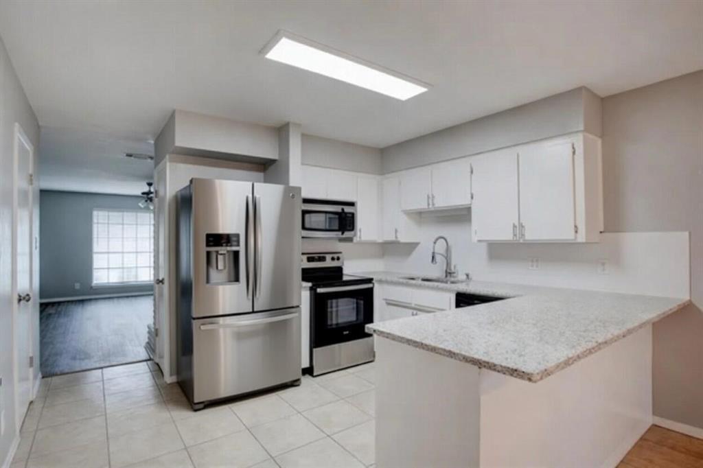 8230 El Retiro Road Fort Worth, TX 76116 - Photo 8 of 21 a kitchen with a refrigerator a microwave and cabinets