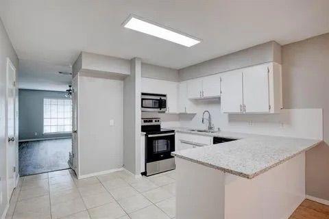8230 El Retiro Road Fort Worth, TX 76116 - Photo 9 of 21 a kitchen with a stove a refrigerator and a sink