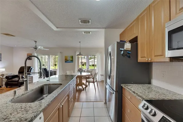 a kitchen with stainless steel appliances granite countertop a sink a stove and a wooden floors