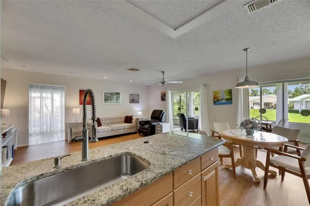 a kitchen with granite countertop a sink and chairs