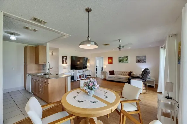 a living room with furniture a flat screen tv and kitchen view