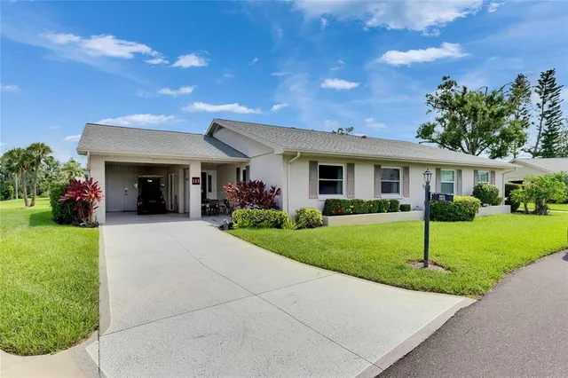 a view of house in front of a big yard with potted plants