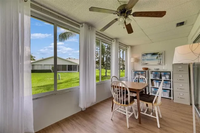a dining room with furniture a chandelier and wooden floor