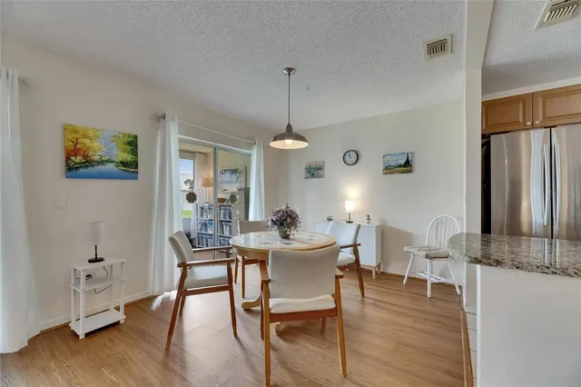a dining room with furniture a chandelier and wooden floor