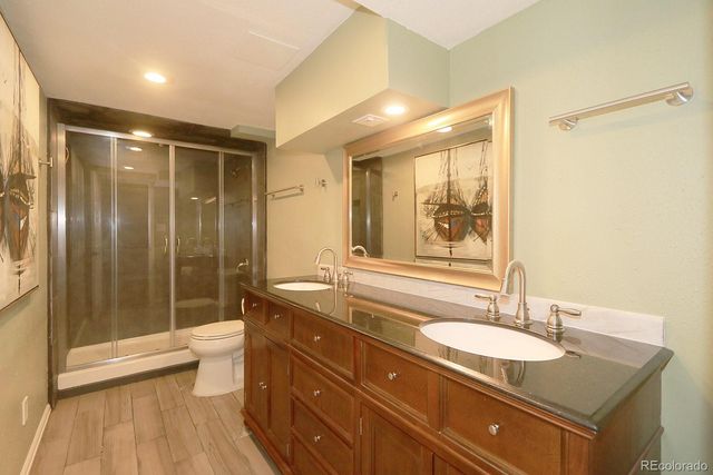 a bathroom with a granite countertop sink shower mirror and toilet
