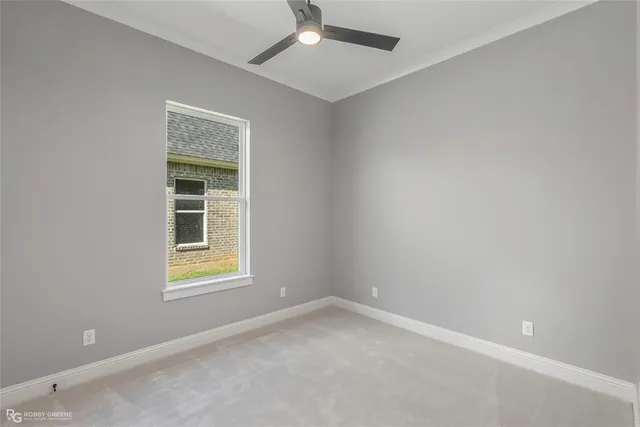 an empty room with a window and ceiling fan