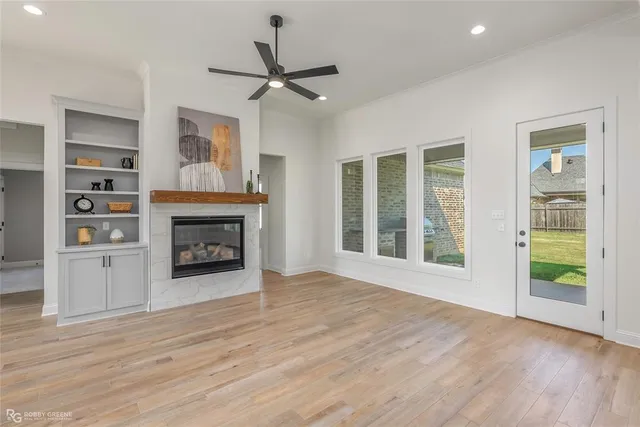 a view of an empty room with a window and fireplace