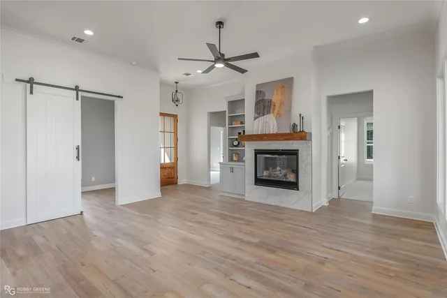 an empty room with wooden floor fireplace and cabinet