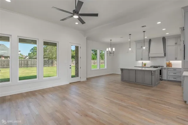 a view of an empty room with kitchen and a window
