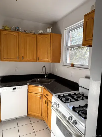 a kitchen with granite countertop a sink a stove and a microwave