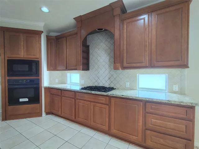a kitchen with granite countertop white cabinets and stainless steel appliances