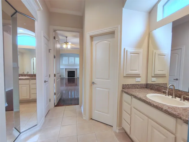 a bathroom with a granite countertop sink two mirror and a shower