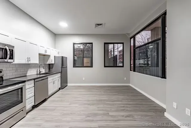 a large kitchen with stainless steel appliances granite countertop a large stove top oven and cabinets