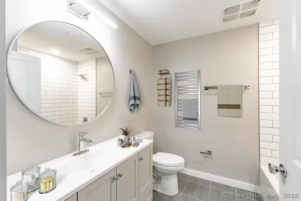 a bathroom with a sink a toilet and a mirror