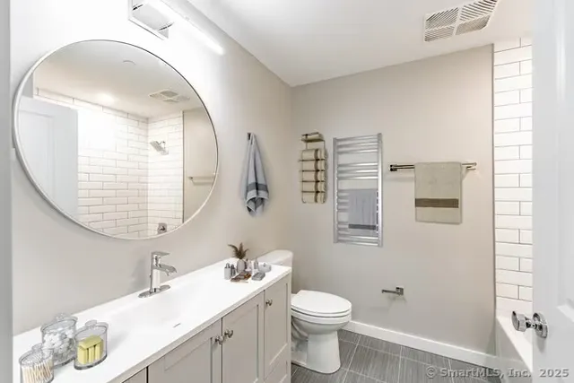 a bathroom with a sink a toilet and a mirror