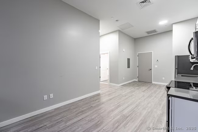 333 State Street, Unit 510 Bridgeport, CT 06604 - Photo 5 of 28 a view of a kitchen with wooden floor and a sink