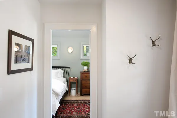 a view of a hallway with wooden floor and a bathroom