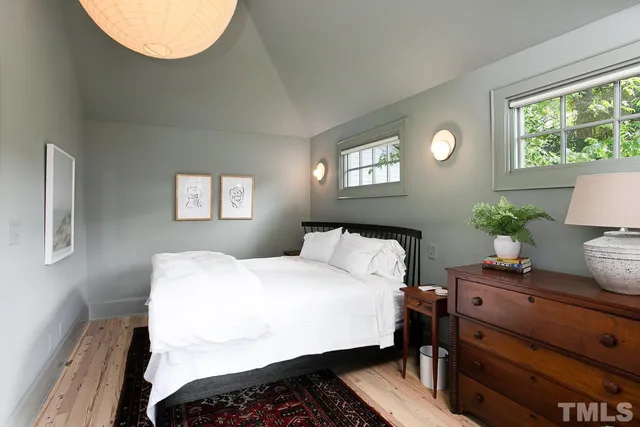a bedroom with a bed and a potted plant