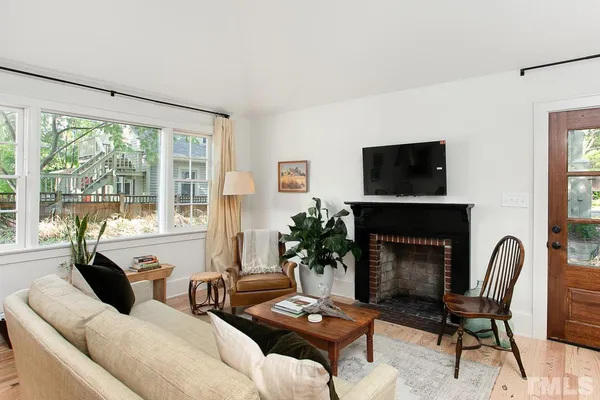 a living room with furniture a fireplace and a large window