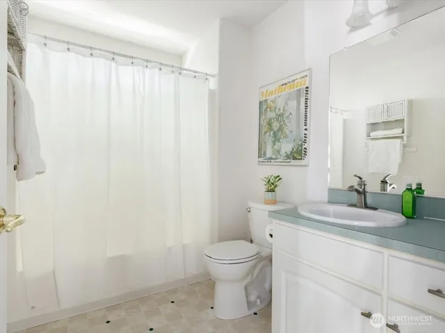 a bathroom with a granite countertop sink a toilet and a mirror